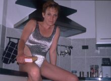 kurzhaarige Hausfrau um die 50 sitzt in der Küche
